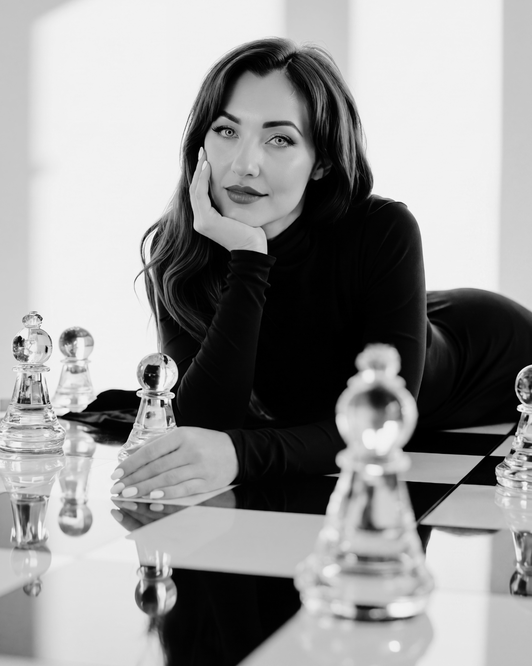 Samantha J at a glass chessboard in black and white